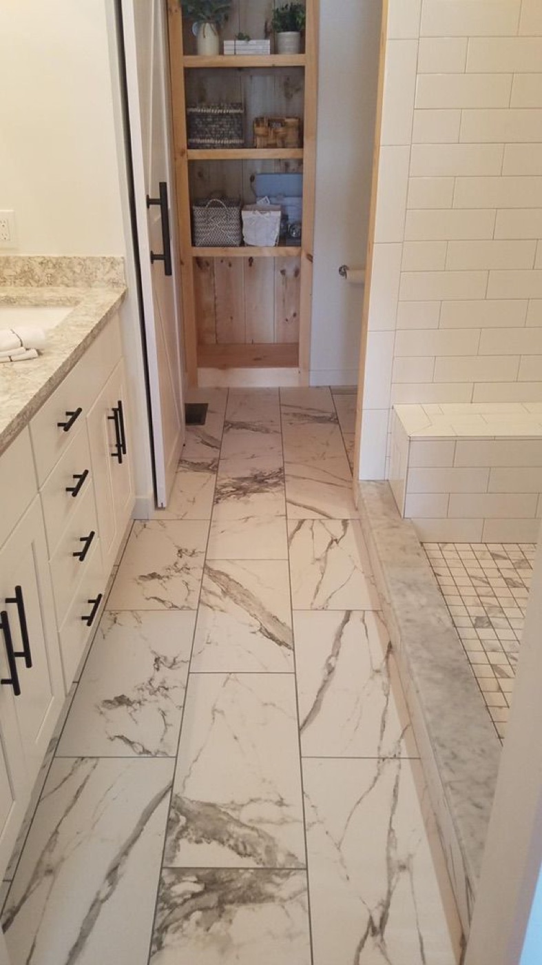 Bathroom remodel with marble-look tile floor and a white vanity