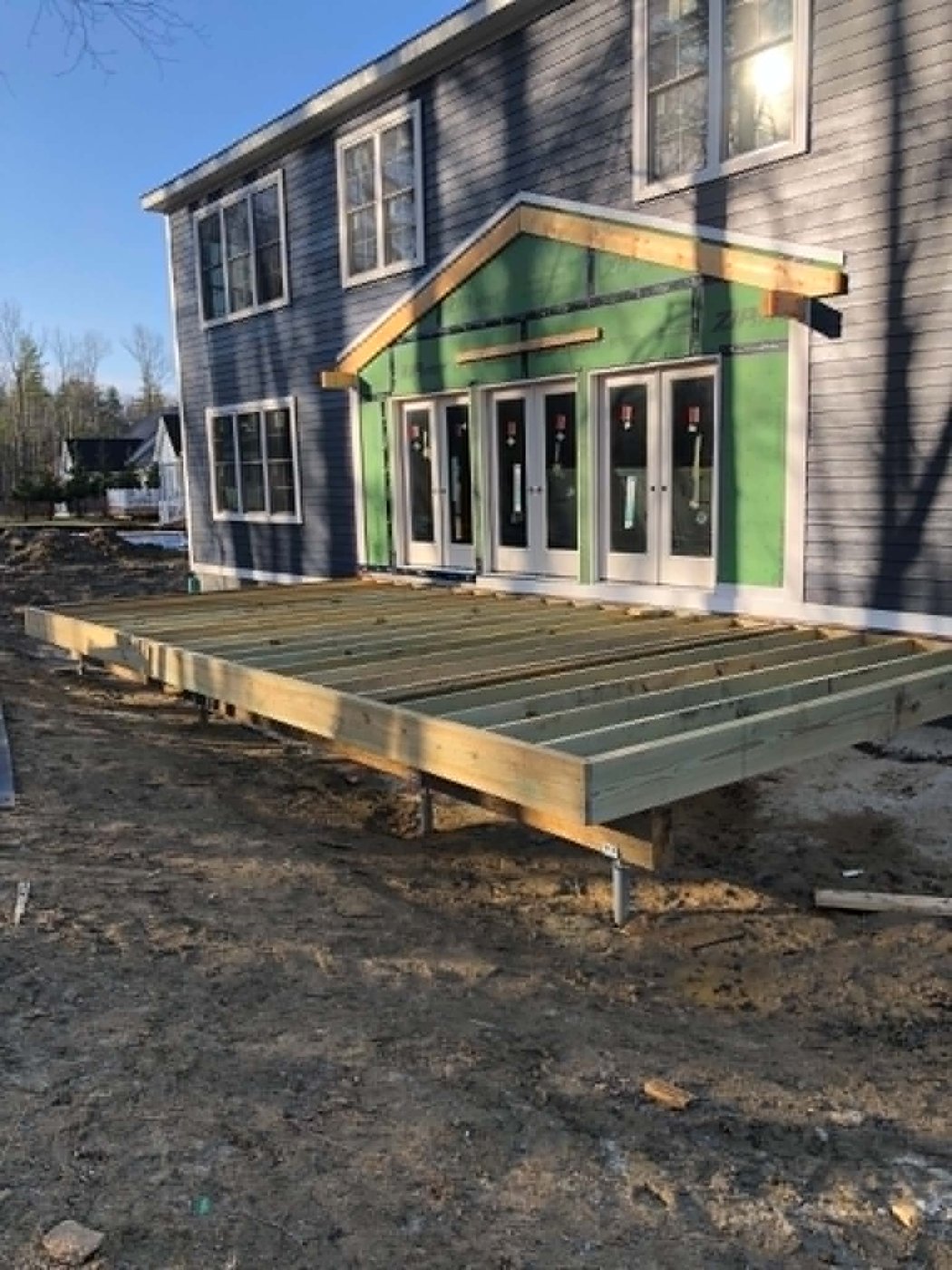 Pressure-treated deck framing on helical piers at a new-build home
