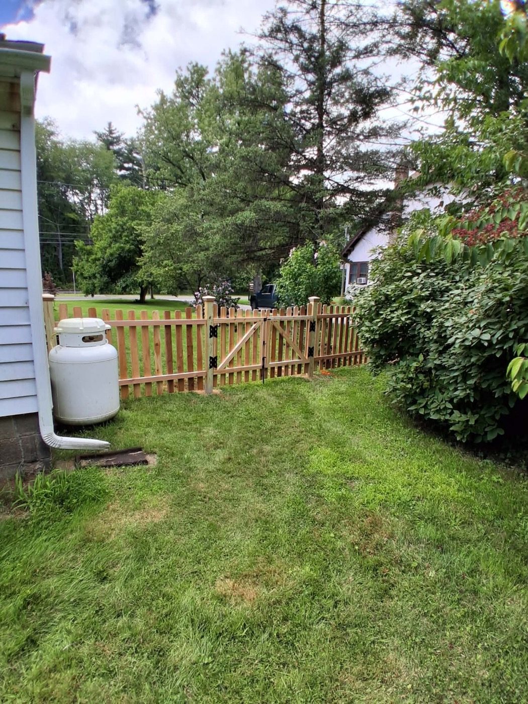 Cedar picket fence and gate enclosing a side yard