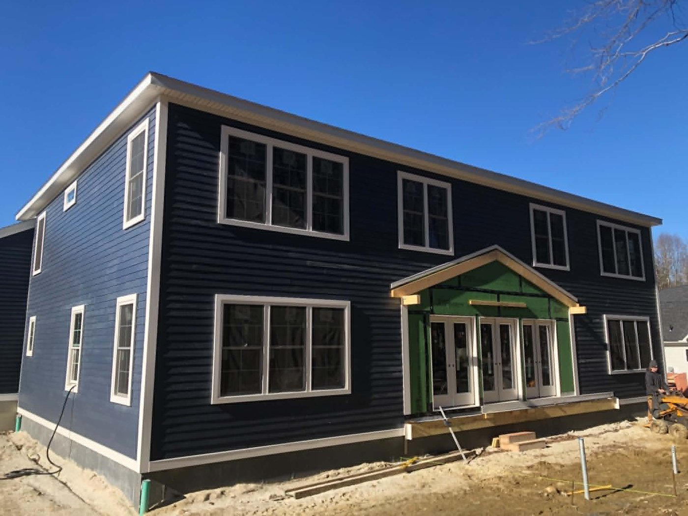 Two-story home with fresh navy clapboard siding and white trim