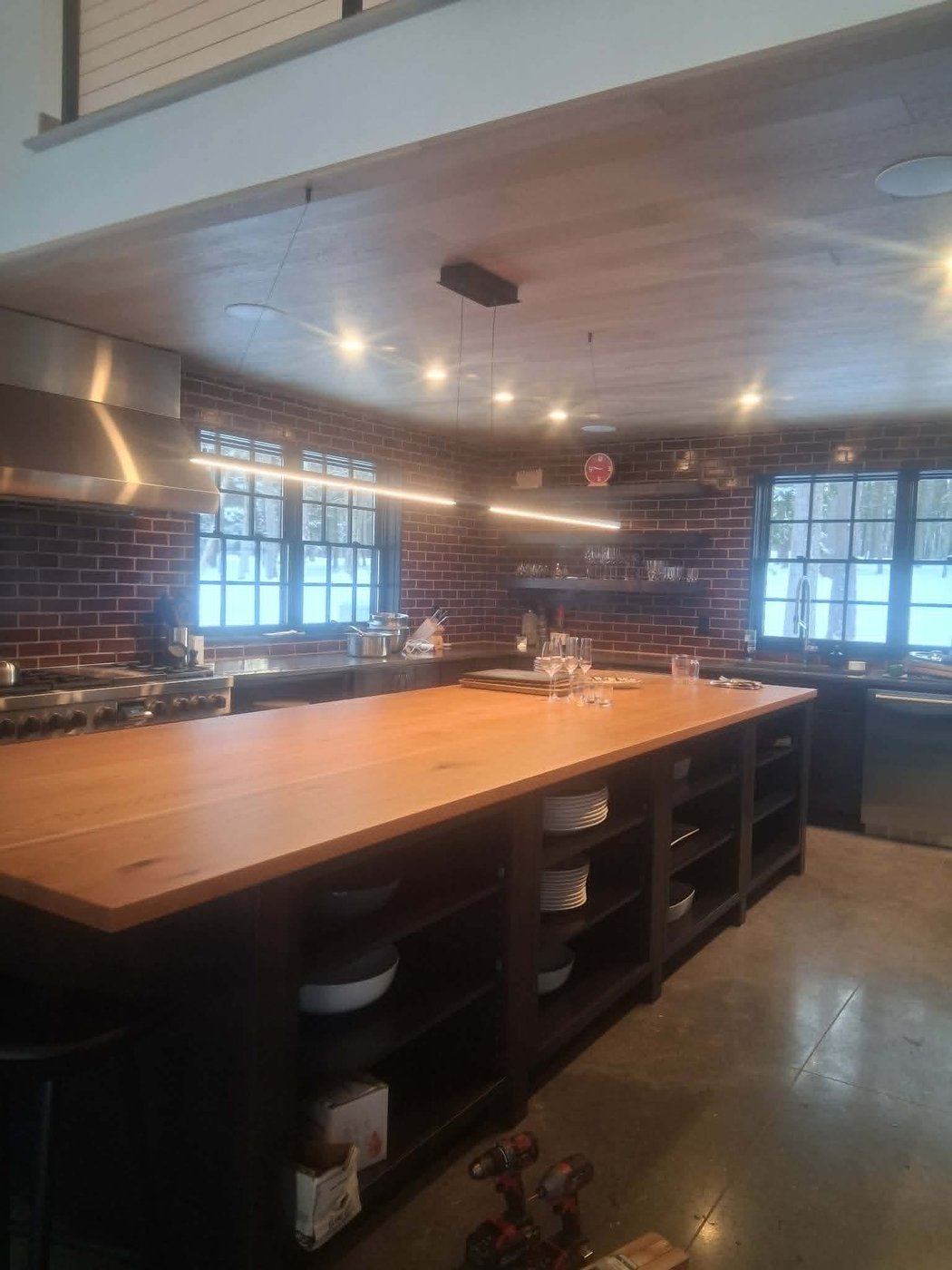 Finished commercial store interior with a custom butcher-block counter, open shelving, and exposed brick