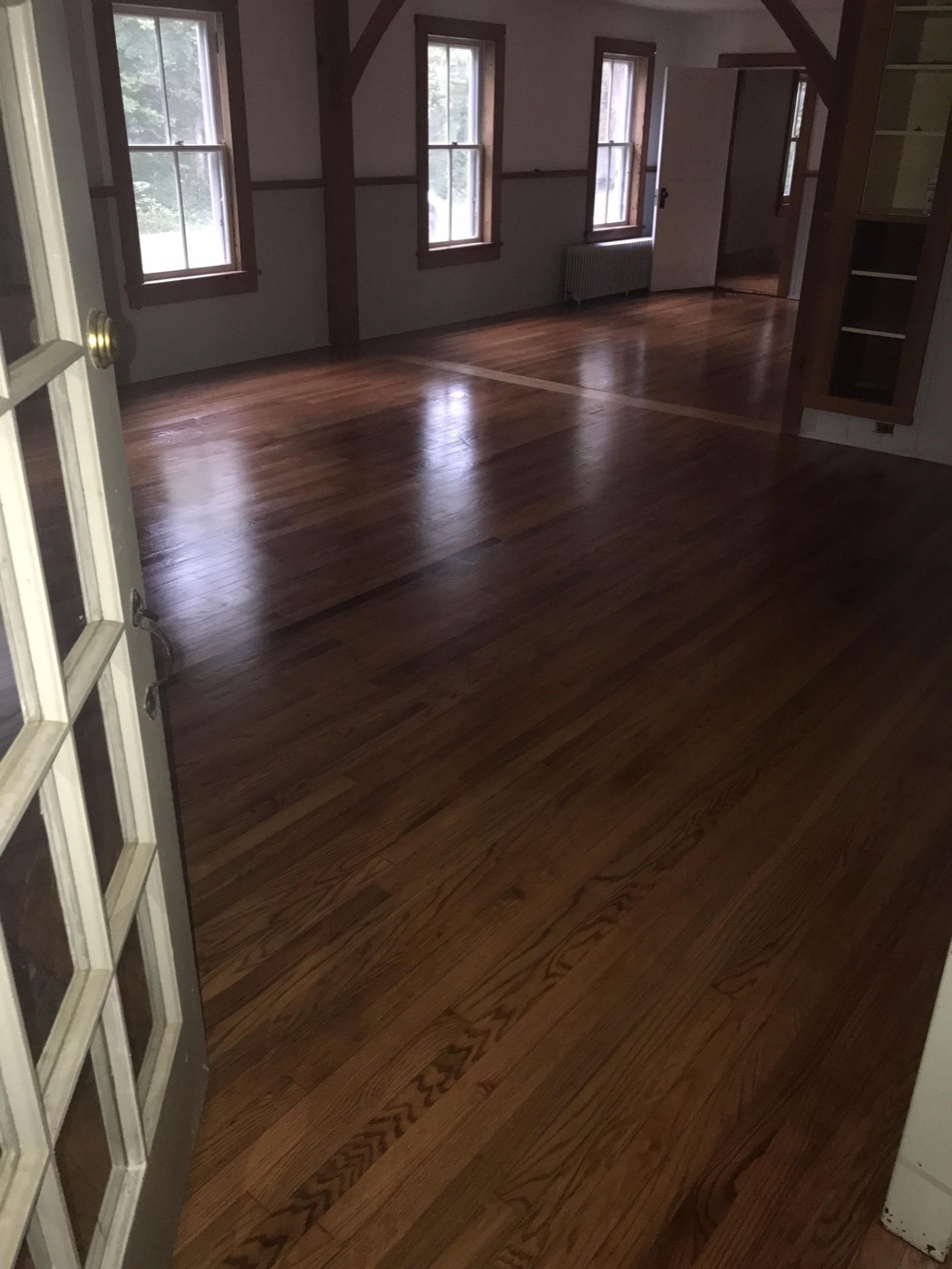 Newly installed hardwood floor running through a bright open room