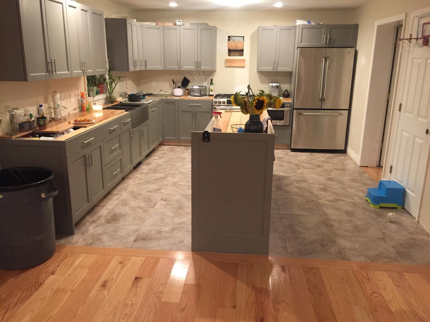 Remodeled kitchen with gray shaker cabinets, stainless appliances, and a center island